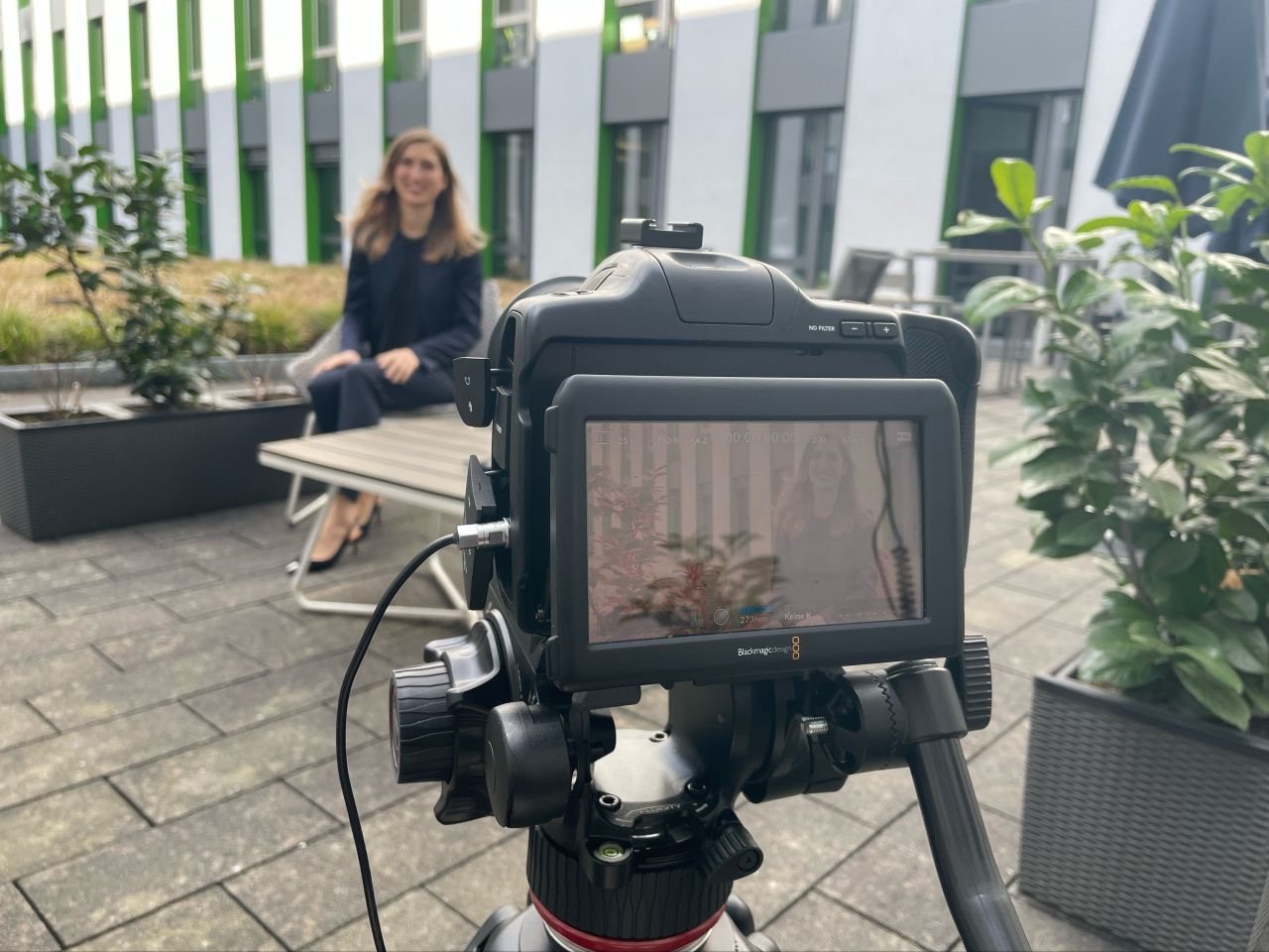 Videodreh im Innenhof, im Hintergrund sitzt Julia Bewerunge